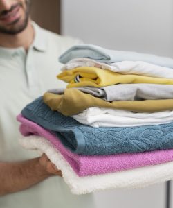 hombre-sujetando-un-monton-de-ropa-limpia